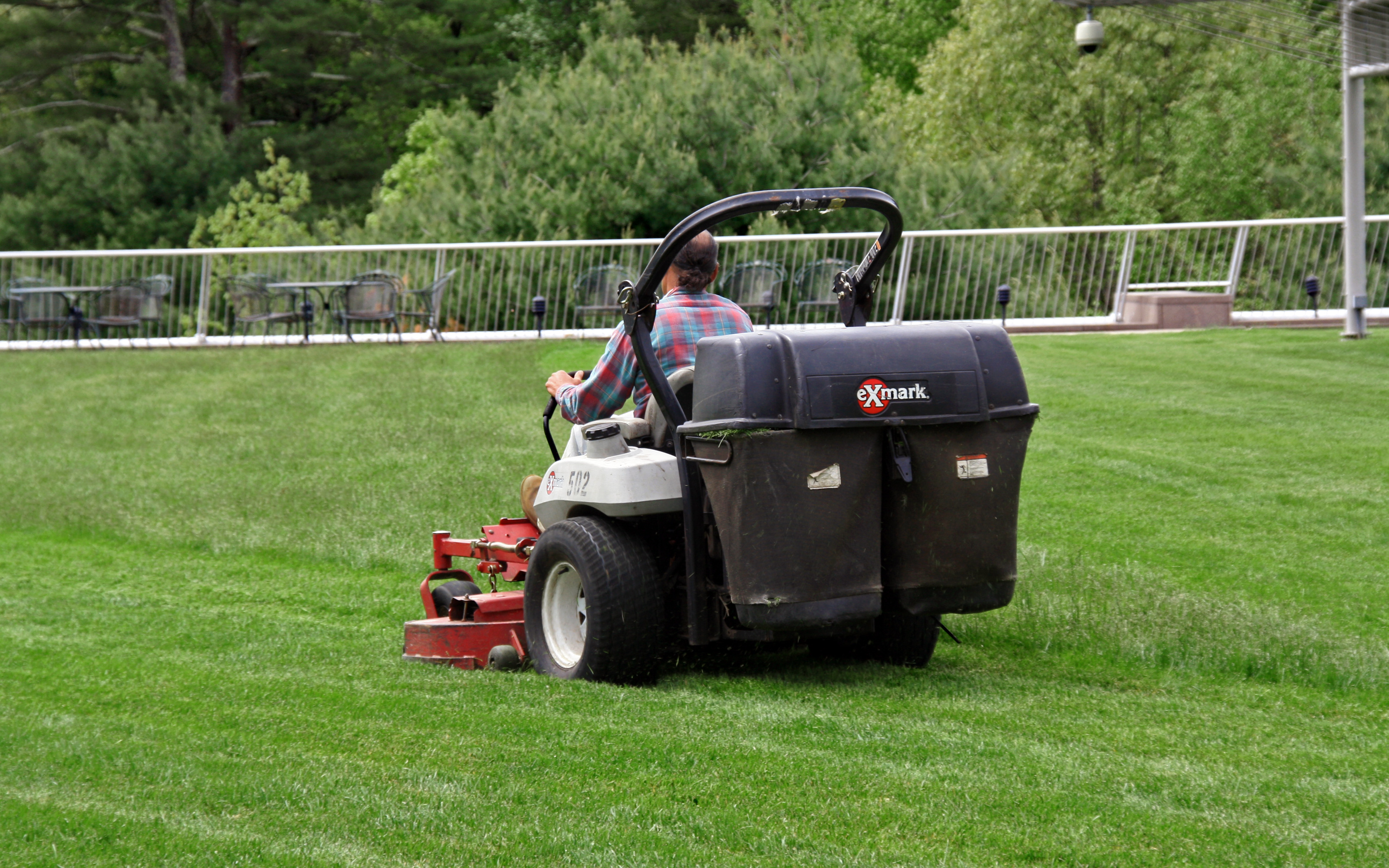 The green roof with its lawn requires intensive maintenance. Man mowing grass on a green roof
